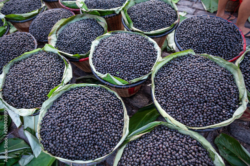 Straw basket full of fresh acai berries to sell at a fair in the city of Belem, Brazil.
