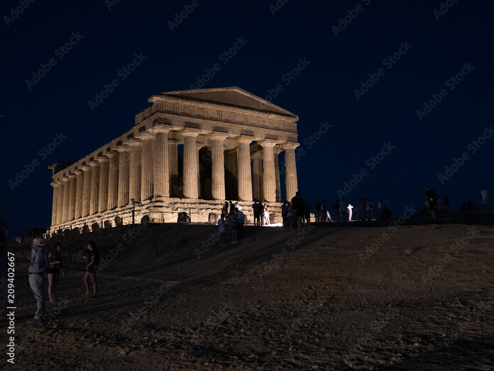 Obraz premium AGRIGENTO, Sicily. August 2017: the Valley of the Temples of Agrigento, an ancient greek temple, perfectly preserved and part of the Unesco World Heritage sites, enlightened at night on the top hill.