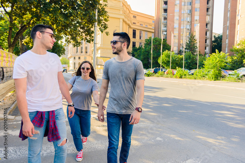 GROUP OF THREE CAREFREE FRIEND TAKE A LEISURELY WALK