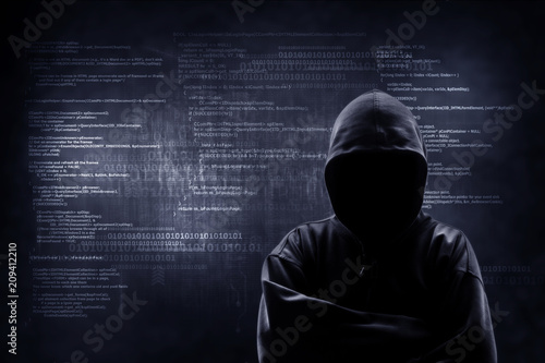 Internet crime concept. Hacker working on a code on dark digital background with digital interface around. photo