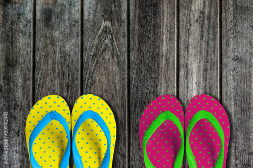Two pairs sandals on wooden background.