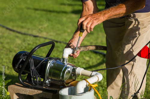Man repairing sprinkler pump and system