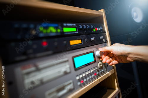 sound engineer hands adjusting professional audio recording signal processor equipment in broadcasting studio