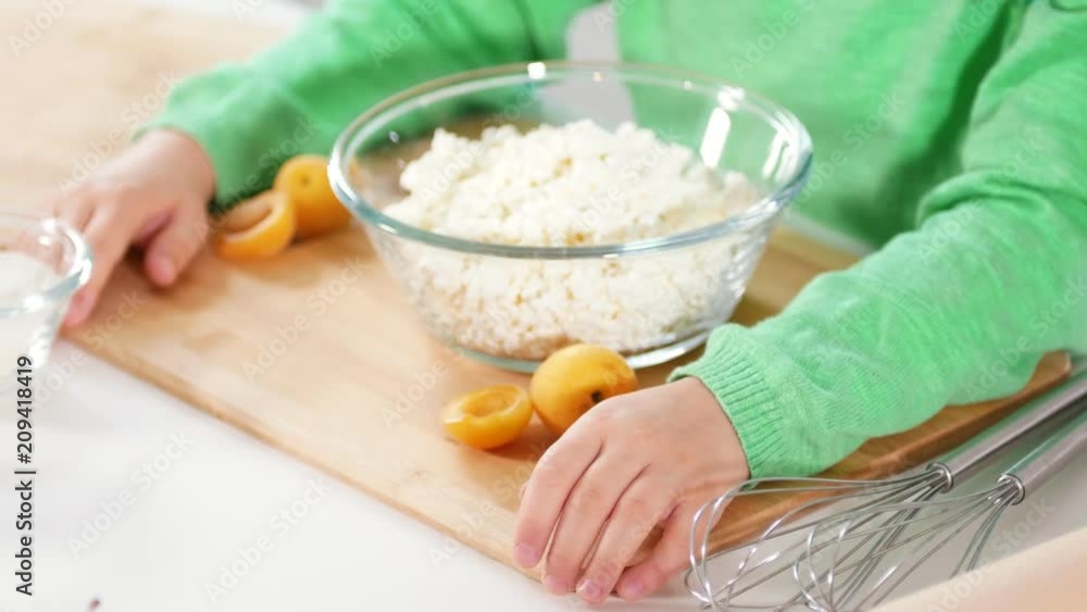Hands of little girl with glass bowl of cottage cheese on the table Hands of little girl with glass bowl of cottage cheese on the table