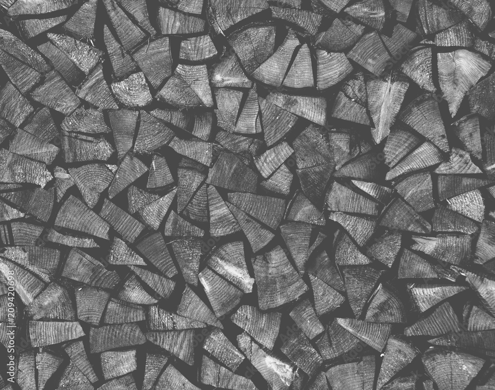Naklejka premium Dry chopped firewood logs ready for winter as background or texture.