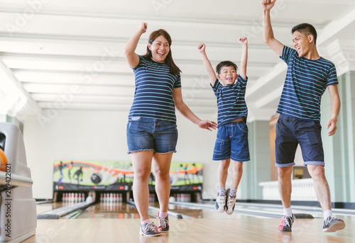 Asian family having fun at bowling club