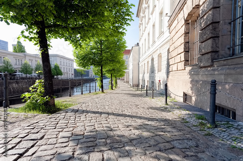 Obraz na plátně Quiet empty side street in historic district, along a river, on a spring afterno