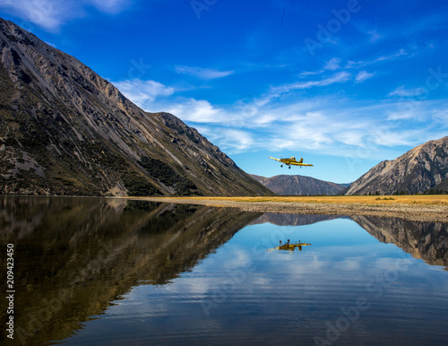 Crop duster flying over Lake Pearson in New Zealand photo