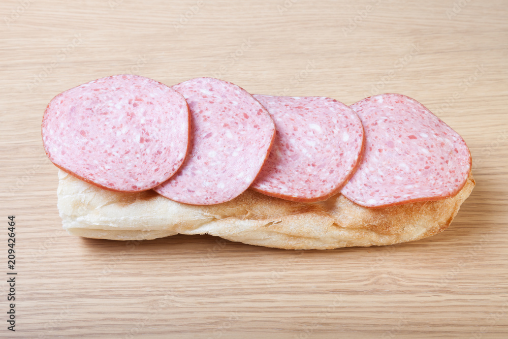 Sausage and bread on a light wooden table. Shallow depth of field. Selective focus Sausage and bread on a light wooden table. Shallow depth of field. Selective focus