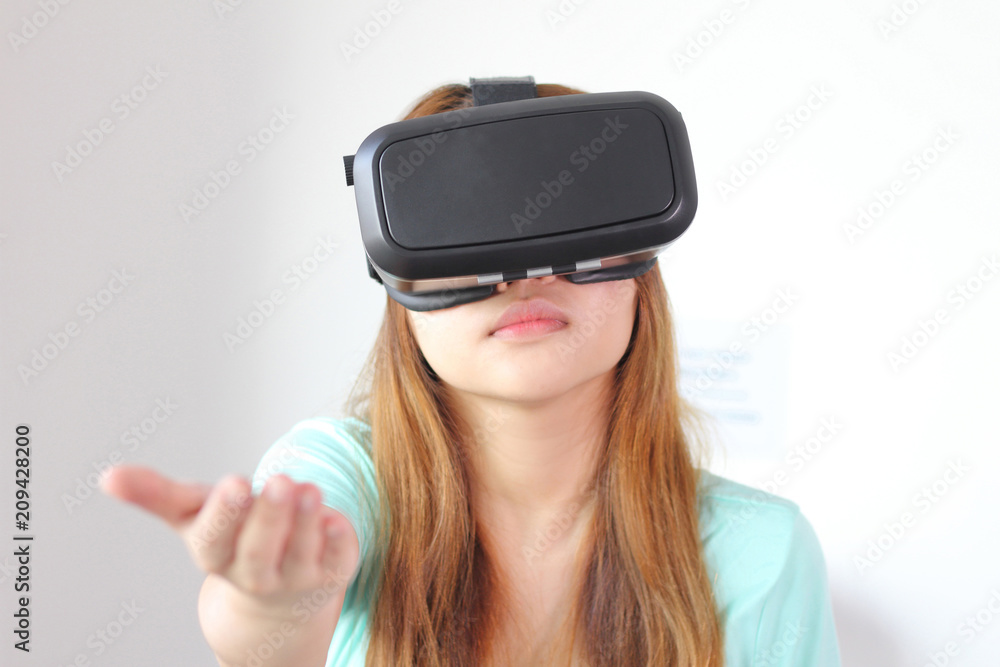 Young woman wearing virtual reality glasses at home. Young woman wearing virtual reality glasses at home.