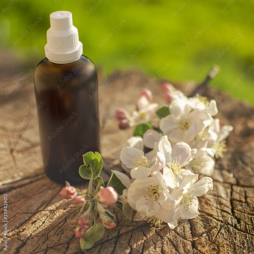 a bottle of cosmetic with an apple tree branch a bottle of cosmetic with an apple tree branch