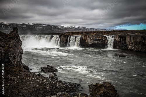 Water of the Godafoss Waterfall - beautiful part of stony rocky desert landscape of Iceland. Toned.
