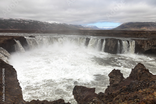 Water of the Godafoss Waterfall - beautiful part of stony rocky desert landscape of Iceland. Toned.