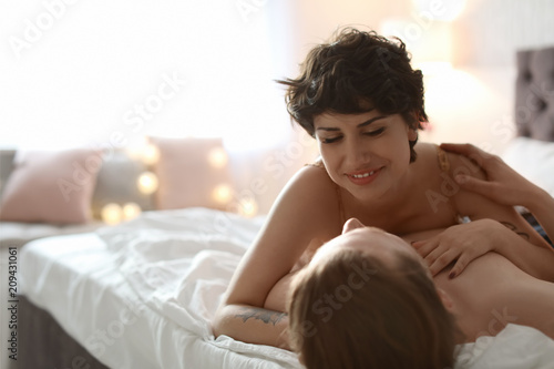 Lovely young couple being intimate on bed at home