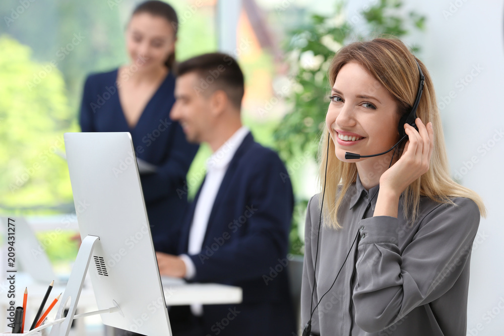 Female receptionist with headset at desk in office Female receptionist with headset at desk in office
