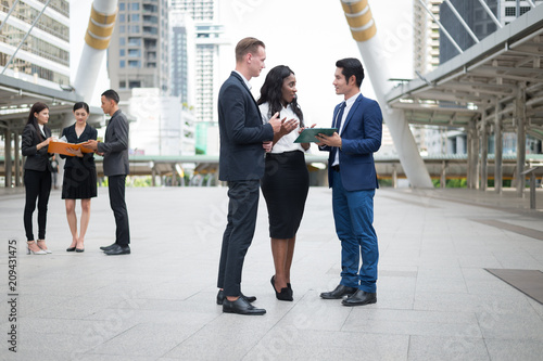 Group of business people standing in the city and discussing ideas for business future. multi culture of business people, African, Caucasian and Asian.