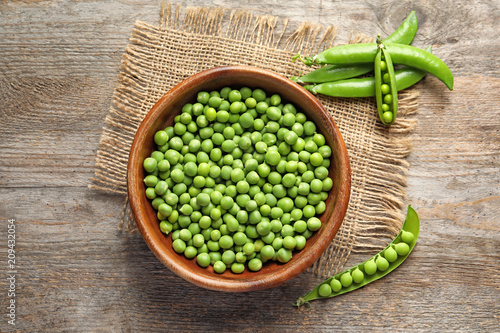 Murais de parede Flat lay composition with green peas on wooden background