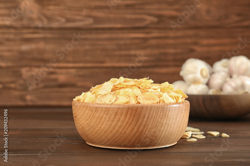Photography Bowl with dried garlic flakes on wooden table