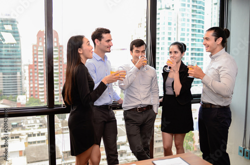 business man are business woman drinking champagne talking and smiling while celebrating in office, successful business concept.