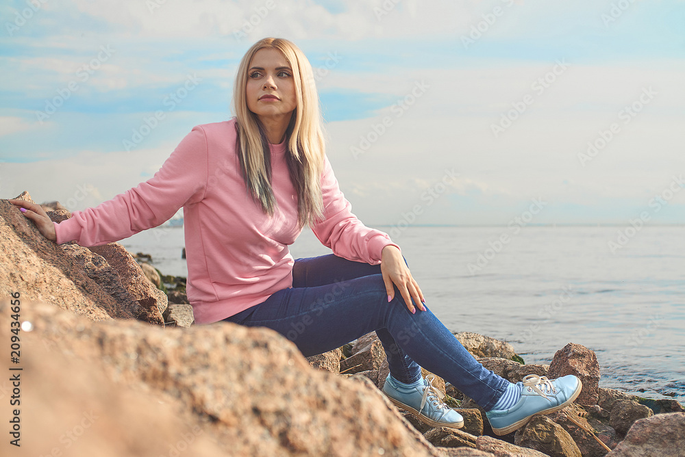 Beautiful girl near the sea. in the lotus position near the stones on the shore. relaxing nature water and sky. Beautiful girl near the sea. in the lotus position near the stones on the shore. relaxing nature water and sky.