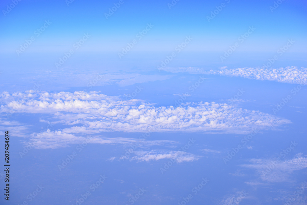 Naklejka premium Sunrise above clouds from airplane window. From above it is not so terrible. The clouds shines from above with the sun. View from airplane