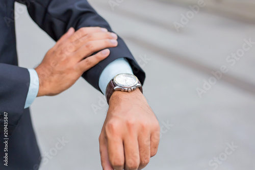 Young Asia handsome businessman looking at his watch