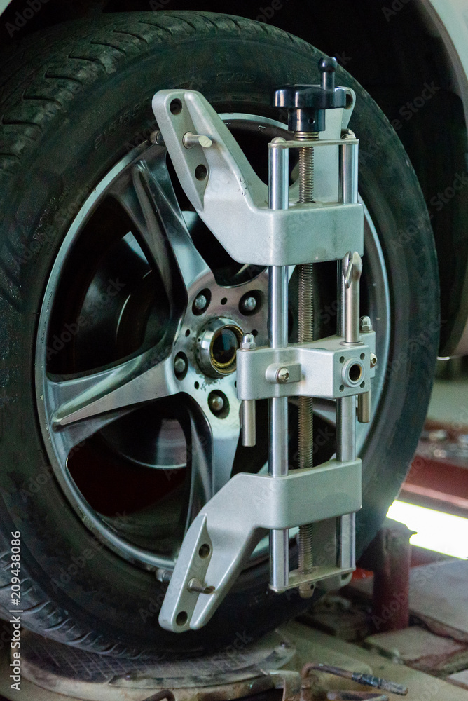 Car on stand with sensors on wheels for wheels alignment camber check in workshop of Service station