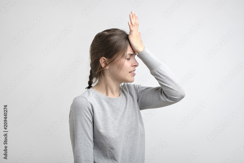 Fototapeta premium young stressed caucasian woman touching her forehead in pain.