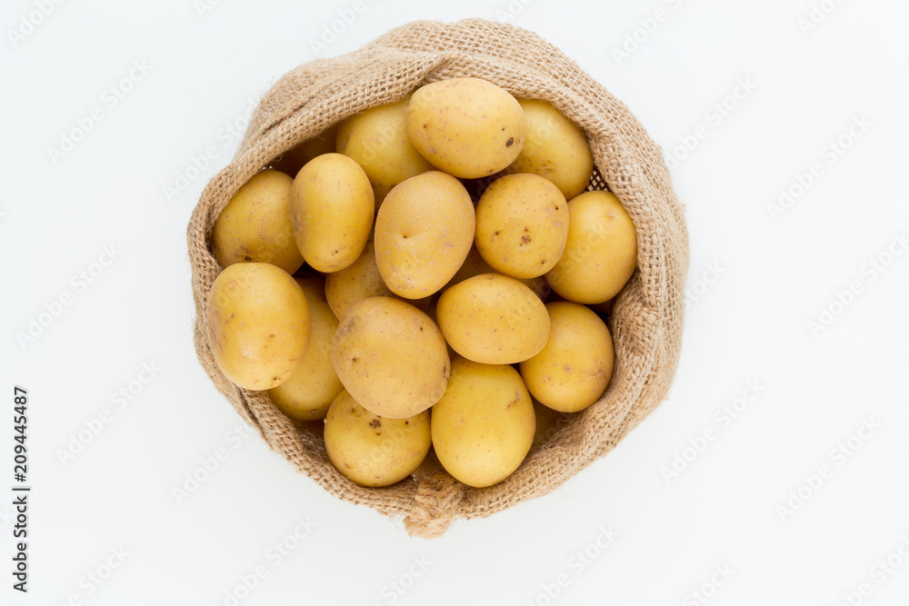 Sack of fresh raw potatoes on wooden background, top view Sack of fresh raw potatoes on wooden background, top view