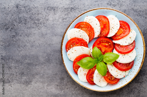 Classic caprese salad. Mozzarella tomatoes and  Basilikum. photo