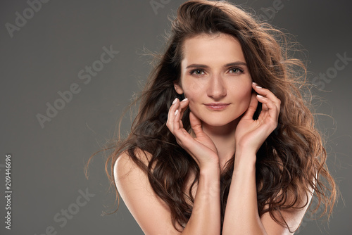 attractive young brunette woman  isolated on grey