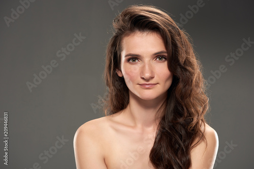 beautiful young naked woman looking at camera, isolated on grey