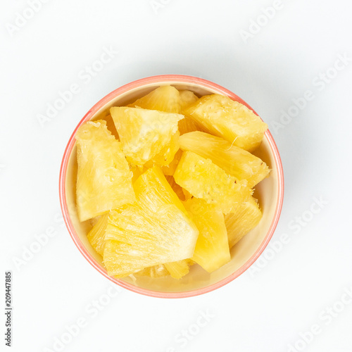 Pineapple in bowl on white background.
