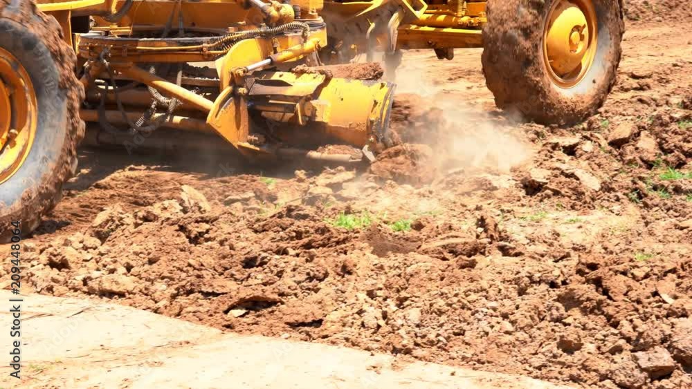 Motor grader or soil road grade plowing soil ground for built site