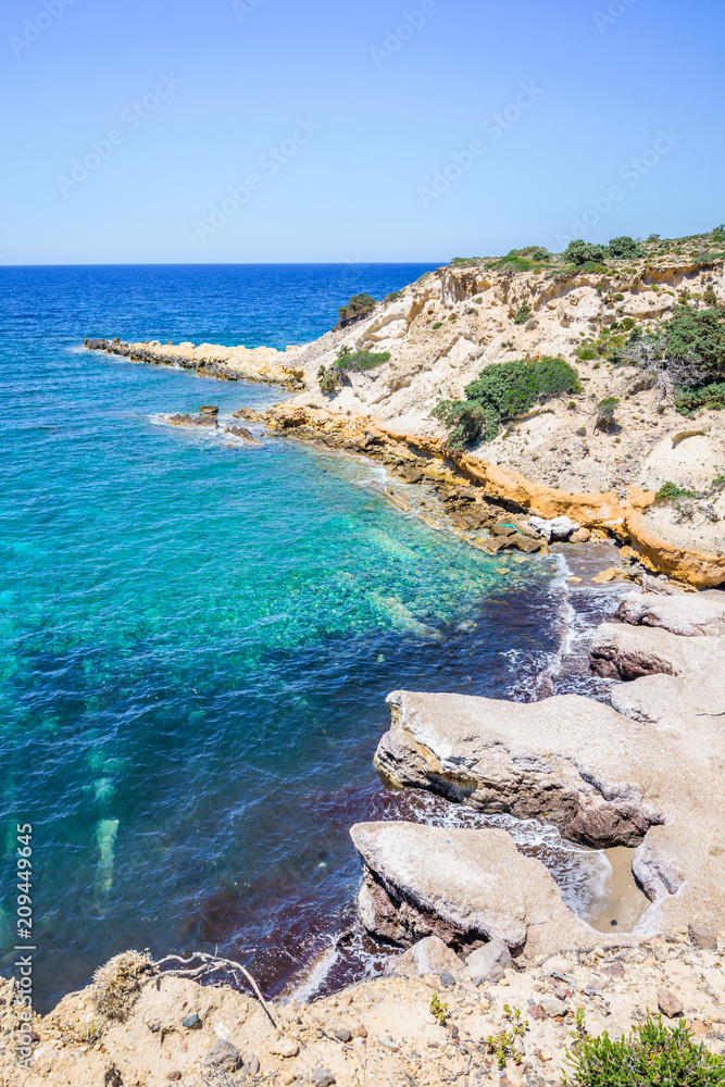 Beach, Greece - Kos Island, Kefalos: Picturesque deep blue Caribbean Bay with wild sea of ​​Greek Agais and steep sandstone cliffs, perfect for wind surfers with heavy waves