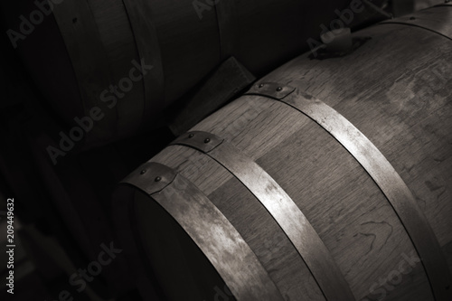 Wooden barrel with red wine in dark winery