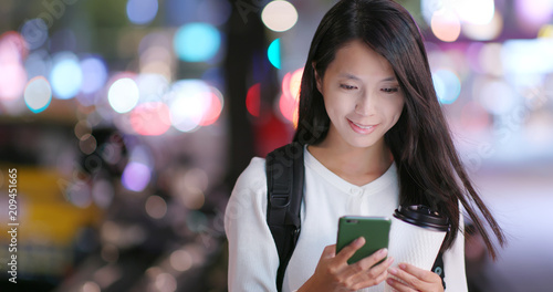 Woman use of mobile phone in the city at night