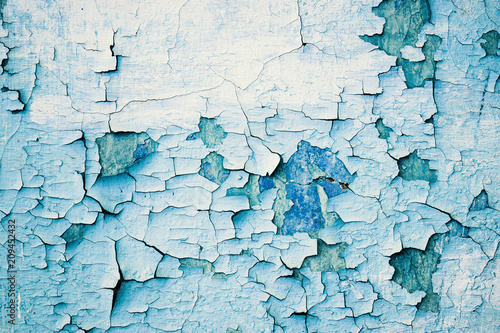 Grunge blue wall with peeling paint, close-up