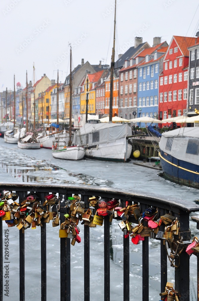 Naklejka premium Colorful locks and houses at Nyhavn in Copenhagen, Denmark- harbor, boat and sea