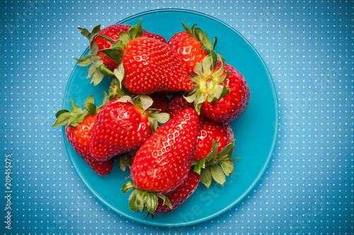 pile of strawberries over blue plate