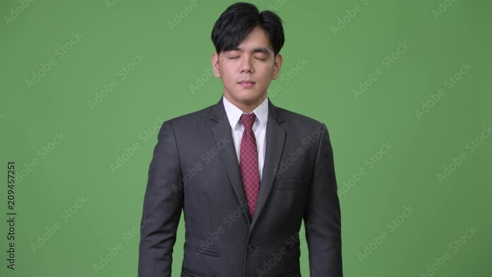 Young handsome Asian businessman relaxing with eyes closed Young handsome Asian businessman relaxing with eyes closed