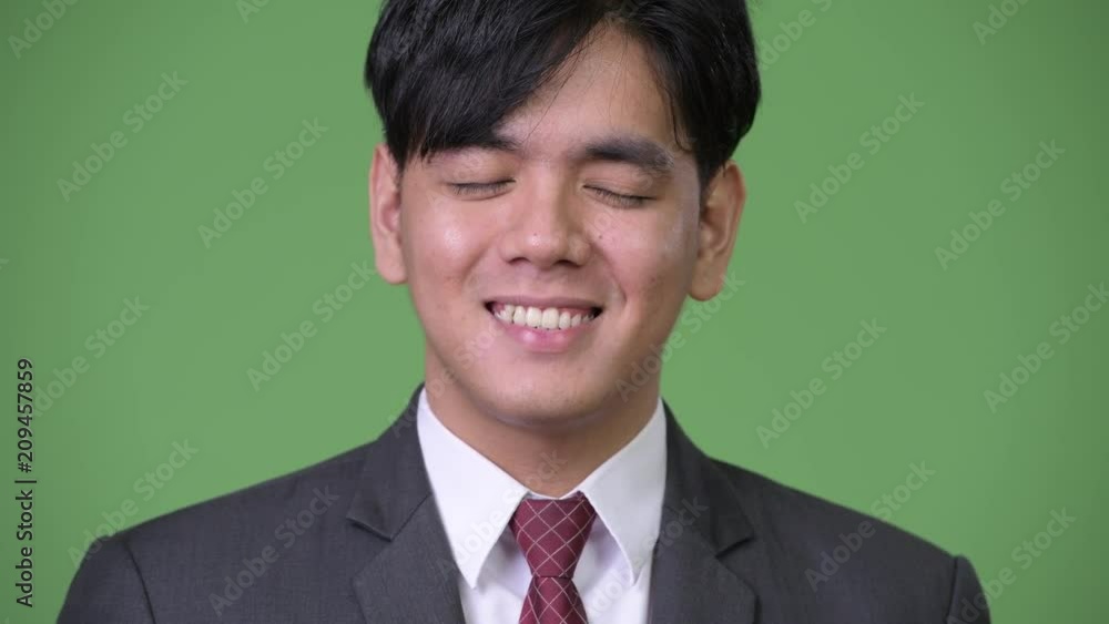 Young handsome Asian businessman relaxing with eyes closed Young handsome Asian businessman relaxing with eyes closed