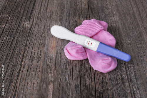 Pregnancy test and baby socks. photo