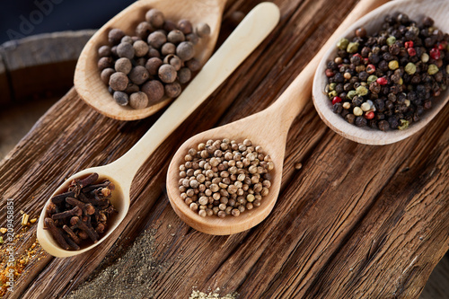 Row of wooden spoons with spices on vintage background, diminishing perspective, close-up, selective focus