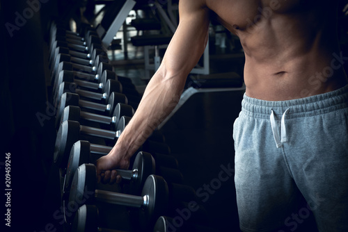 Strong bodybuilder man lifting weights in the sport gym, close up ,bodybuilding and muscle building concept.