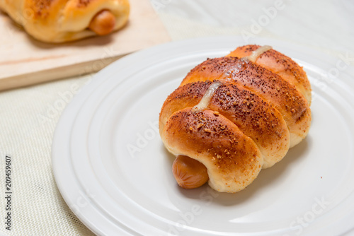 closeup delicious baked sausage bread roll on wooden background