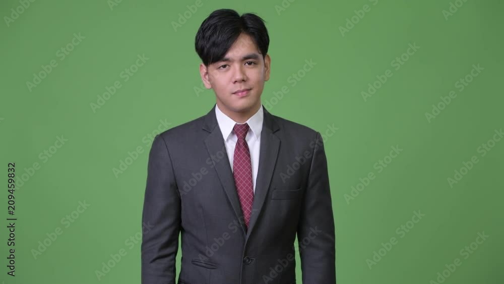 Young handsome Asian businessman nodding head no Young handsome Asian businessman nodding head no