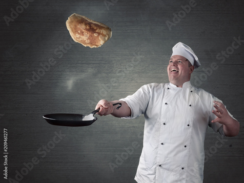 Koch wendet frische Pfannkuchen in der Pfanne
