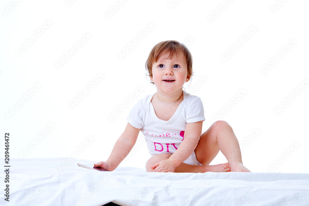 Cute toddler girl is having fun while eating pasta on white background