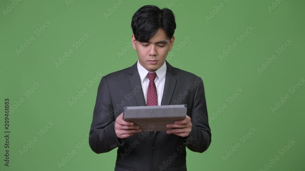 Young handsome Asian businessman using digital tablet Young handsome Asian businessman using digital tablet